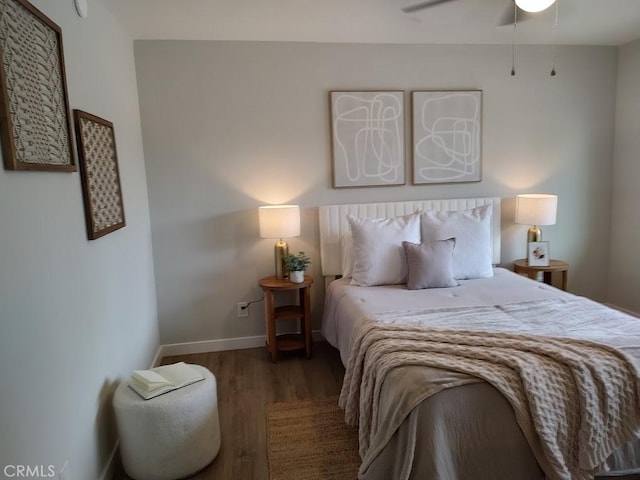 bedroom with ceiling fan, baseboards, and wood finished floors