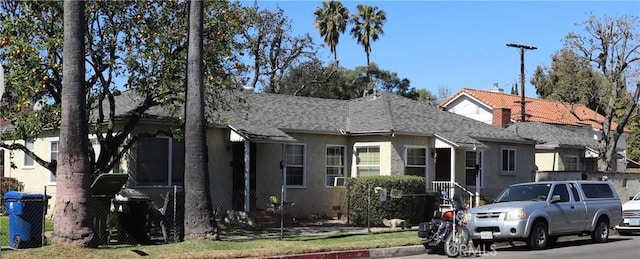 view of front of house featuring a shingled roof and stucco siding