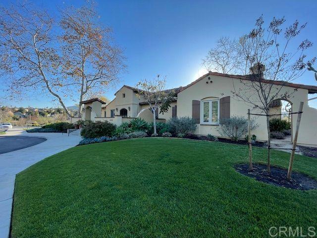 view of front of house with a front yard, driveway, and stucco siding