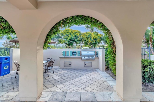 view of patio / terrace with fence, an outdoor kitchen, and area for grilling