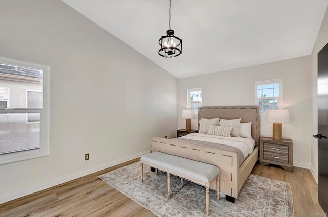 bedroom featuring light wood-style floors, baseboards, and vaulted ceiling