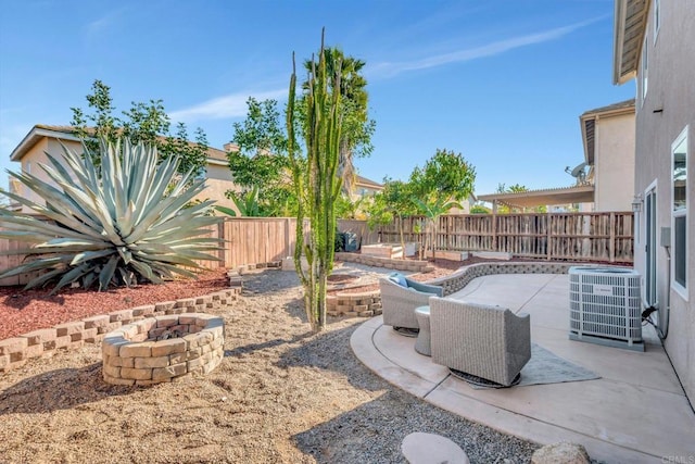 view of patio / terrace with an outdoor fire pit, cooling unit, and a fenced backyard