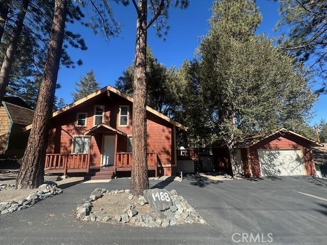 chalet / cabin featuring a garage and covered porch