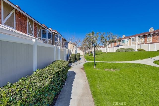 view of property's community featuring a yard, fence, and a residential view