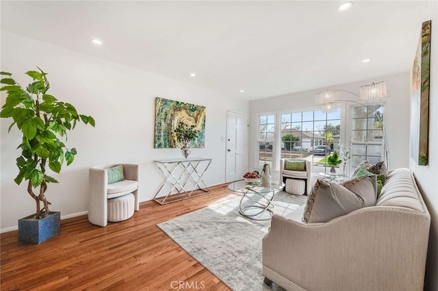 living area featuring a notable chandelier, wood finished floors, and recessed lighting