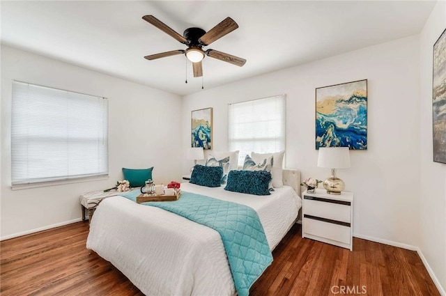 bedroom with dark wood-style floors, baseboards, and a ceiling fan