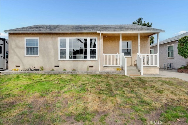 view of front of property with a shingled roof, a front yard, a porch, and stucco siding