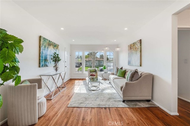 living room featuring baseboards, wood finished floors, and recessed lighting