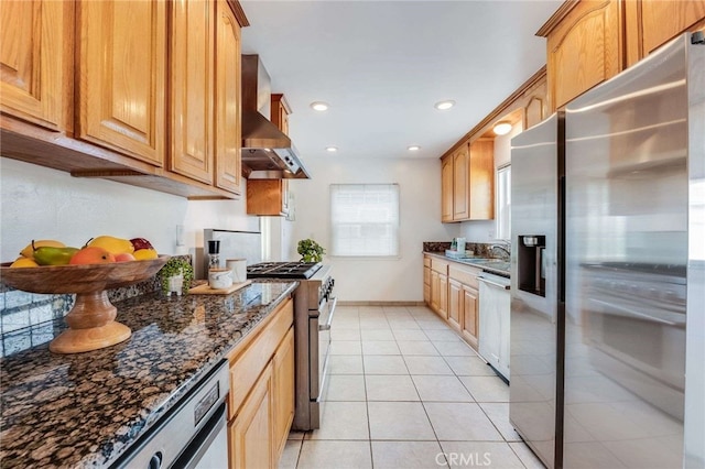 kitchen with light tile patterned floors, dark stone countertops, extractor fan, stainless steel appliances, and recessed lighting