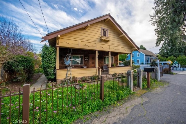 view of front facade featuring a porch, a gate, and a fenced front yard