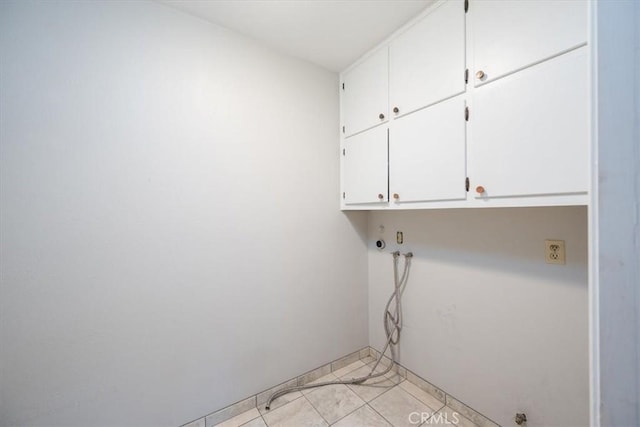 laundry room with light tile patterned floors and cabinet space