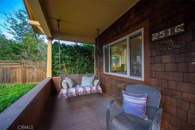 view of patio with covered porch and fence