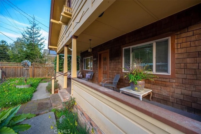 view of patio / terrace featuring covered porch and fence