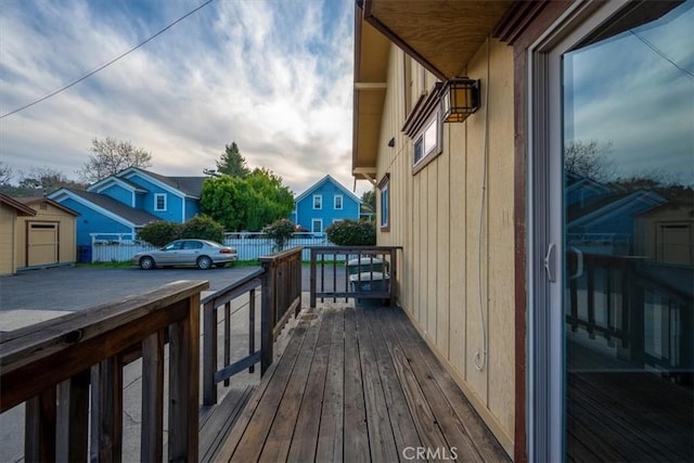 wooden terrace featuring a residential view and fence