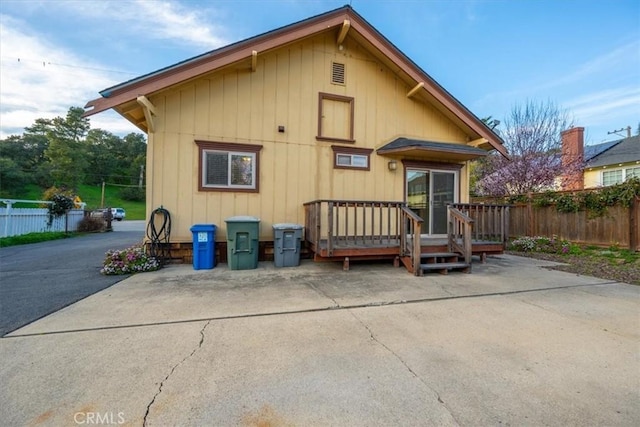 back of property featuring a deck, a patio, and fence