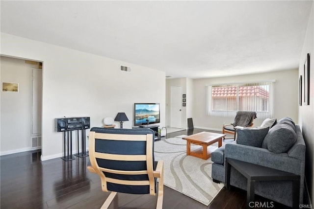 living room with dark wood-style floors, visible vents, and baseboards