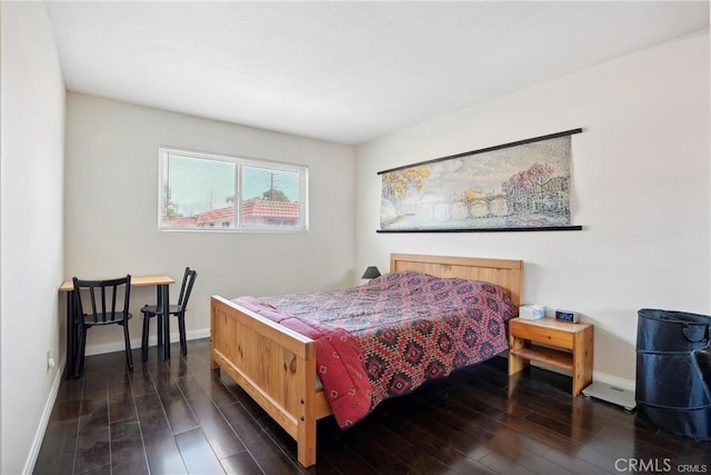 bedroom with dark wood finished floors and baseboards