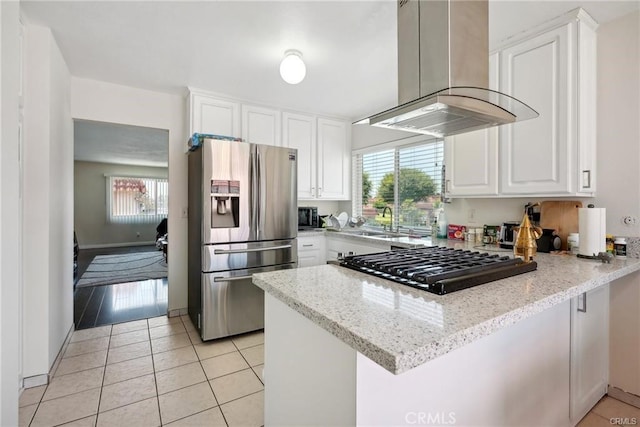 kitchen with light stone counters, island range hood, a peninsula, white cabinetry, and stainless steel refrigerator with ice dispenser