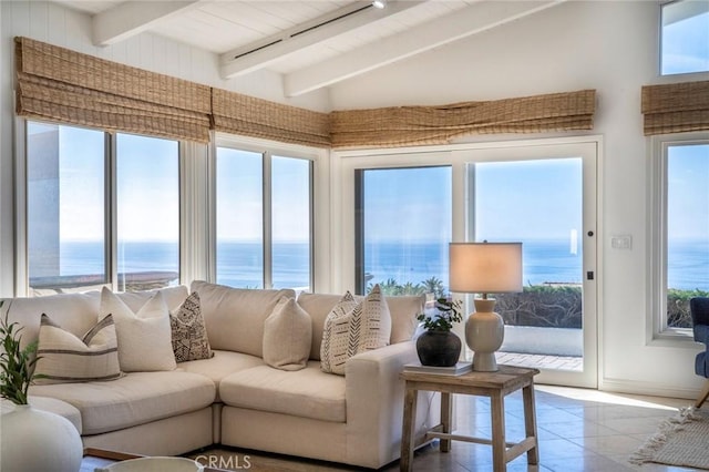 tiled living area with a water view, vaulted ceiling with beams, and a wealth of natural light