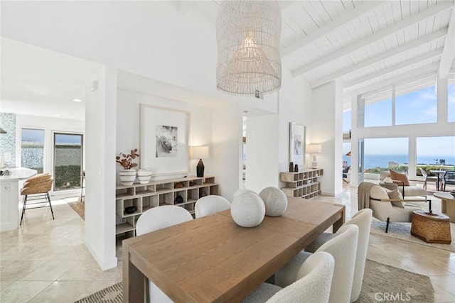 dining space with high vaulted ceiling, a healthy amount of sunlight, a water view, and beam ceiling