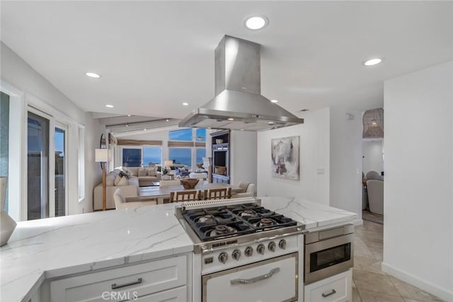 kitchen with open floor plan, stainless steel appliances, island exhaust hood, and white cabinets