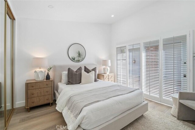 bedroom featuring light wood-style floors, recessed lighting, a closet, and access to exterior