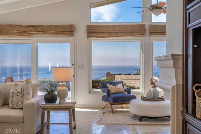 sunroom featuring a water view and ceiling fan