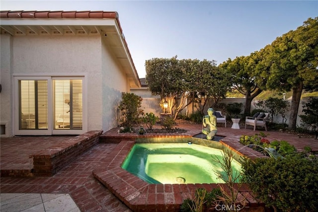 view of swimming pool featuring an in ground hot tub, a fenced backyard, and a patio