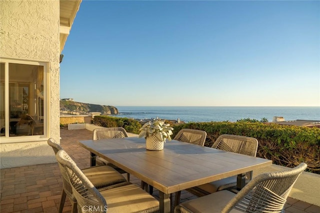 view of patio with outdoor dining space and a water view