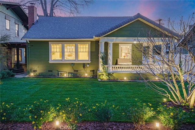 bungalow-style house featuring a shingled roof, a lawn, a chimney, crawl space, and a porch