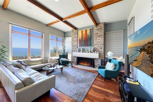 living room featuring dark wood-style flooring, beamed ceiling, a water view, a fireplace, and recessed lighting