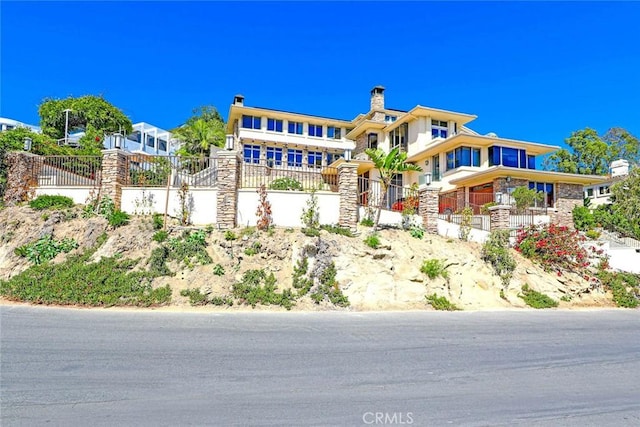 view of front of house featuring stone siding and fence