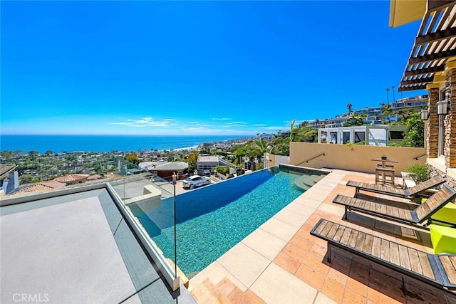 view of swimming pool featuring a water view, an infinity pool, and a patio area