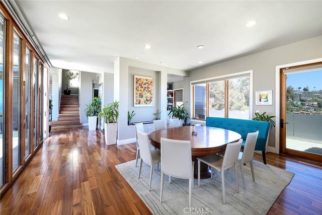 dining space with stairs, recessed lighting, baseboards, and wood finished floors