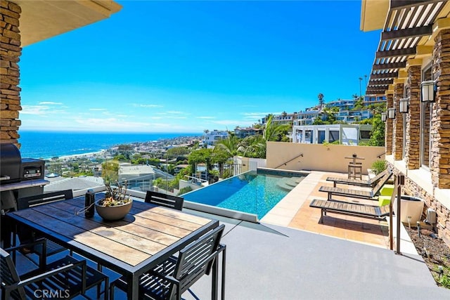 pool featuring outdoor dining area, a water view, and a patio