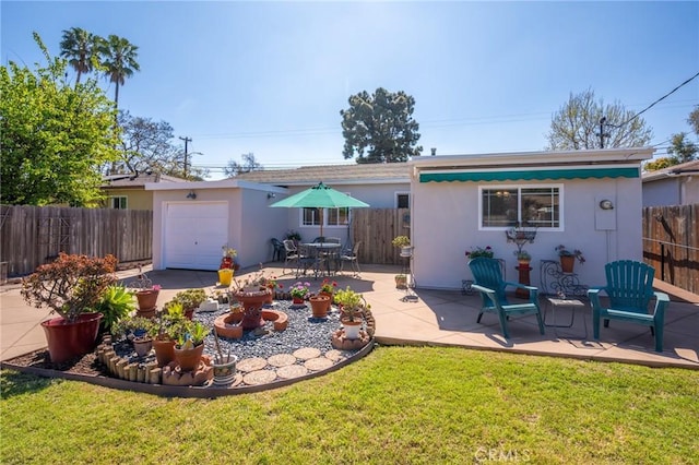 back of property featuring a lawn, stucco siding, a fenced backyard, an outdoor structure, and a patio