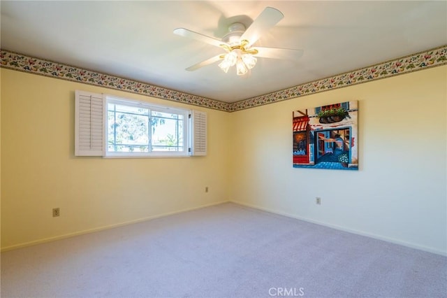 carpeted spare room with baseboards and ceiling fan