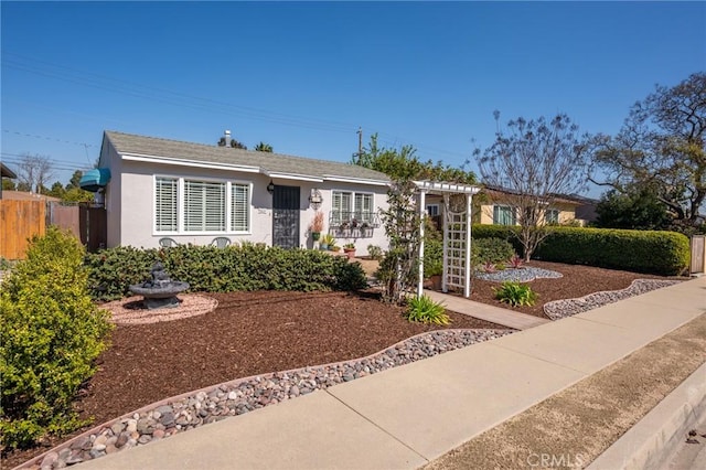 ranch-style home with stucco siding and fence