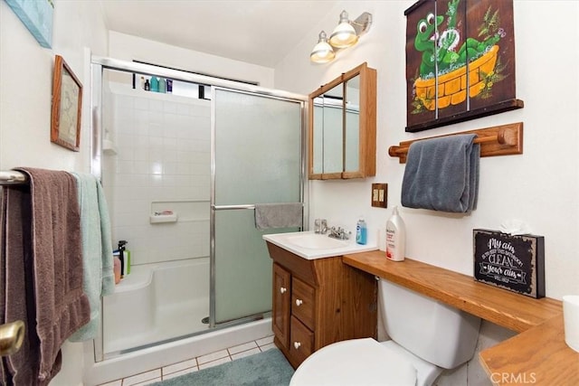 full bathroom featuring toilet, a stall shower, vanity, and tile patterned floors