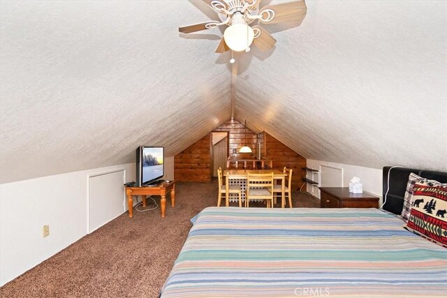 carpeted bedroom with a ceiling fan, vaulted ceiling, and a textured ceiling