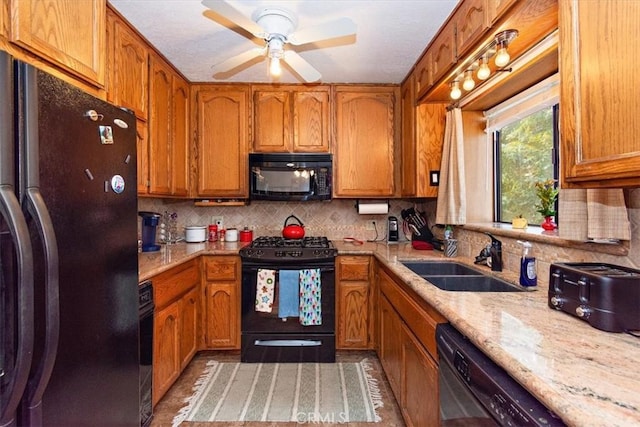 kitchen featuring tasteful backsplash, brown cabinets, a sink, and black appliances