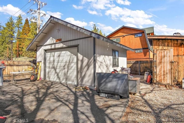 view of outbuilding featuring fence and an outbuilding