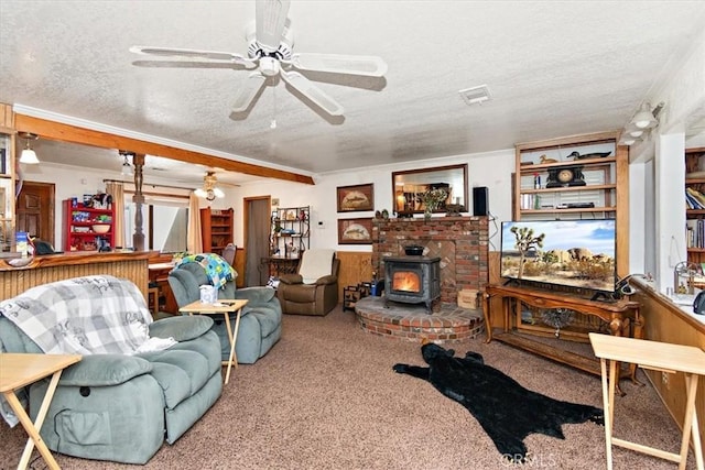 living area with carpet, visible vents, a wood stove, ceiling fan, and a textured ceiling