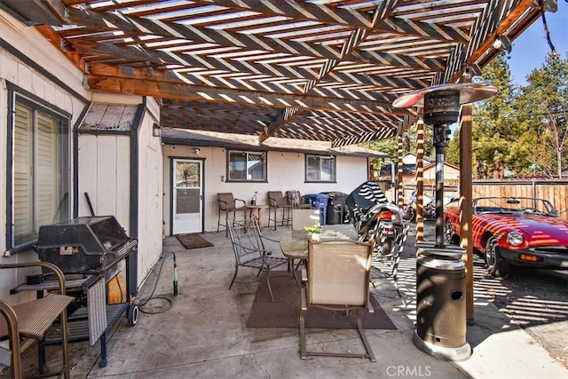 view of patio featuring a grill, fence, a pergola, and outdoor dining space