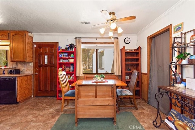 dining space with a wainscoted wall, ceiling fan, visible vents, and crown molding