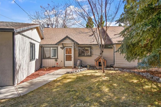 view of front of home featuring roof with shingles and a front lawn