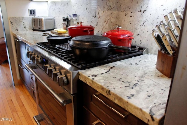 kitchen featuring high end stove, a toaster, and light wood-style flooring