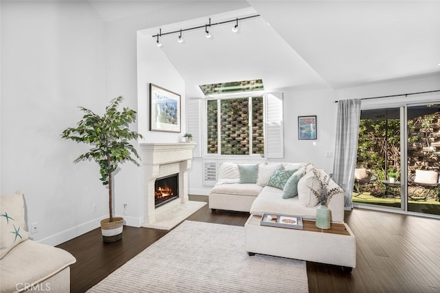 living area with lofted ceiling, baseboards, dark wood finished floors, and a high end fireplace