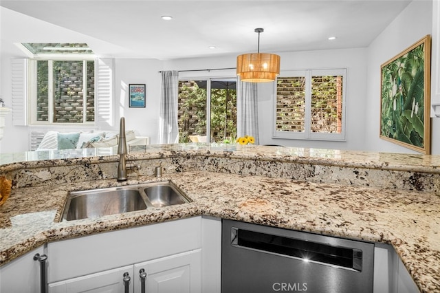 kitchen with a sink, light stone countertops, recessed lighting, and dishwasher