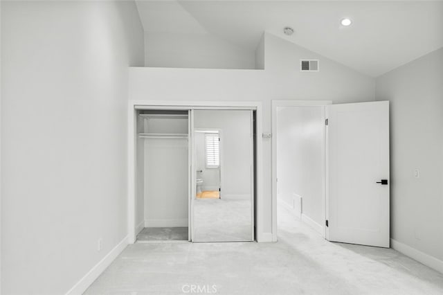 unfurnished bedroom featuring visible vents, lofted ceiling, carpet, and a closet